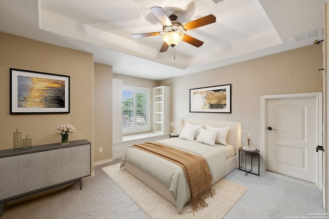 37 Westerleigh, San Antonio, TX 78218 - bedroom featuring a tray ceiling, light carpet, baseboards, and a ceiling fan