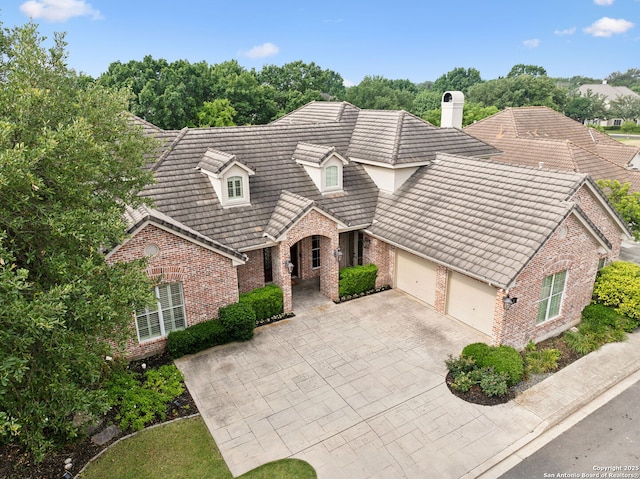 37 Westerleigh, San Antonio, TX 78218 - traditional-style house featuring brick siding, an attached garage, driveway, and a chimney