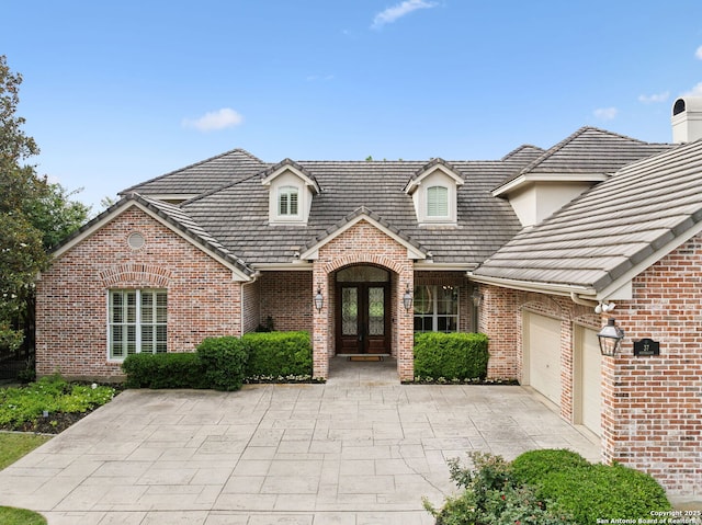 37 Westerleigh, San Antonio, TX 78218 - view of front of house featuring french doors, brick siding, an attached garage, and driveway