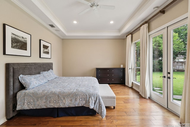37 Westerleigh, San Antonio, TX 78218 - bedroom with multiple windows, a tray ceiling, access to outside, wood-type flooring, and crown molding