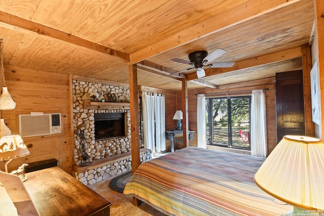 bedroom with a stone fireplace, wooden ceiling, wooden walls, beam ceiling, and a wall mounted air conditioner