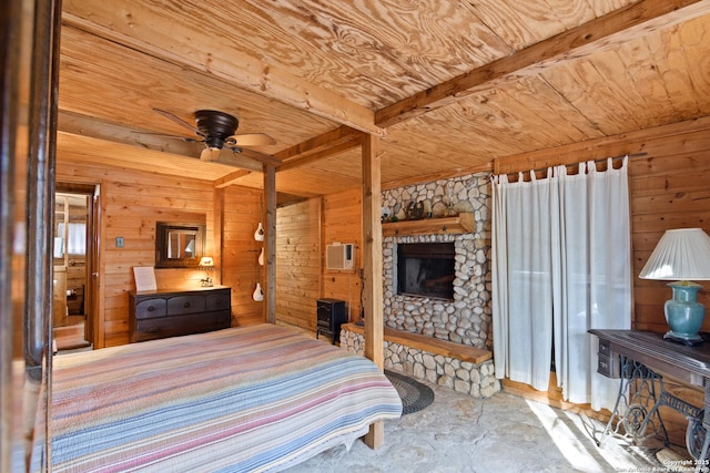 bedroom with beam ceiling, wooden walls, a stone fireplace, wooden ceiling, and a wall mounted air conditioner