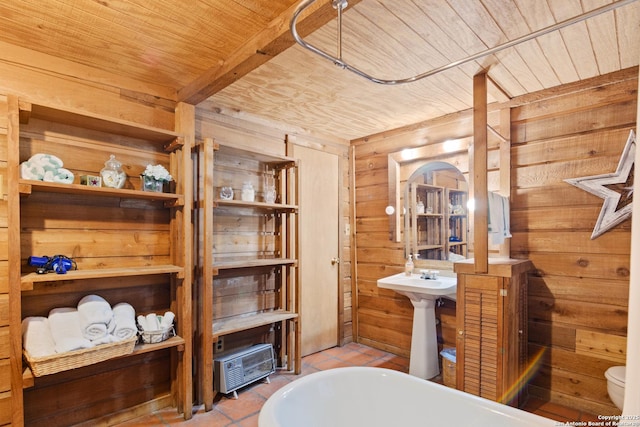 bathroom featuring a freestanding tub, wood ceiling, and wood walls