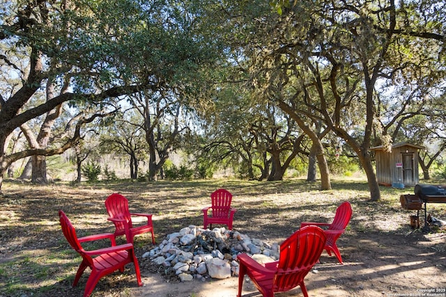 exterior space featuring a shed, a fire pit, and an outbuilding