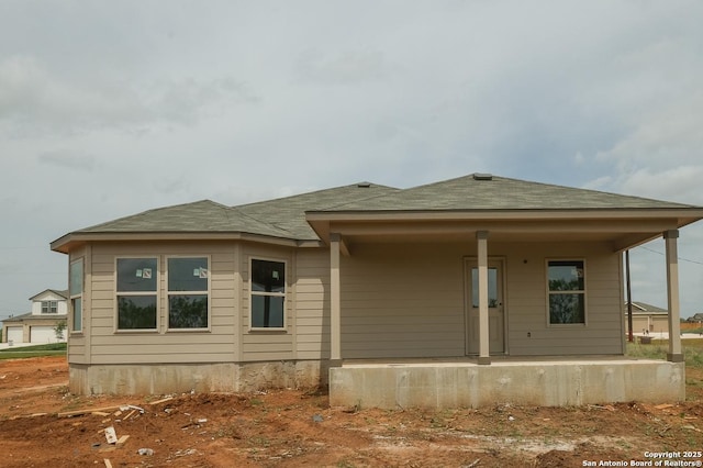 view of front facade featuring covered porch and a shingled roof