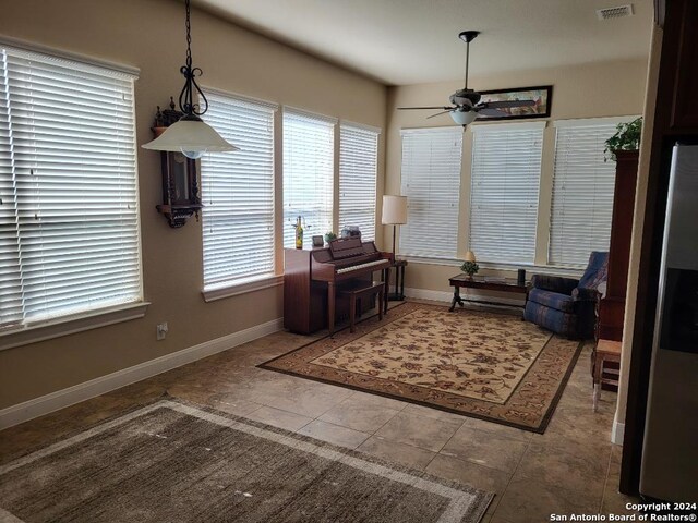 sitting room featuring baseboards, visible vents, and ceiling fan