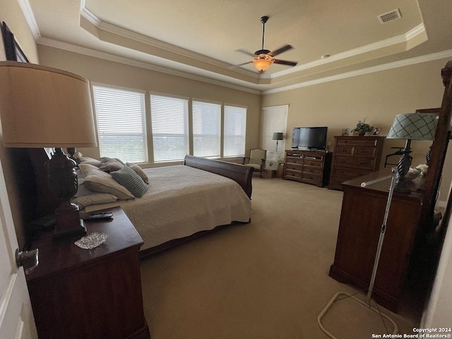 bedroom featuring ornamental molding, a tray ceiling, visible vents, and light colored carpet