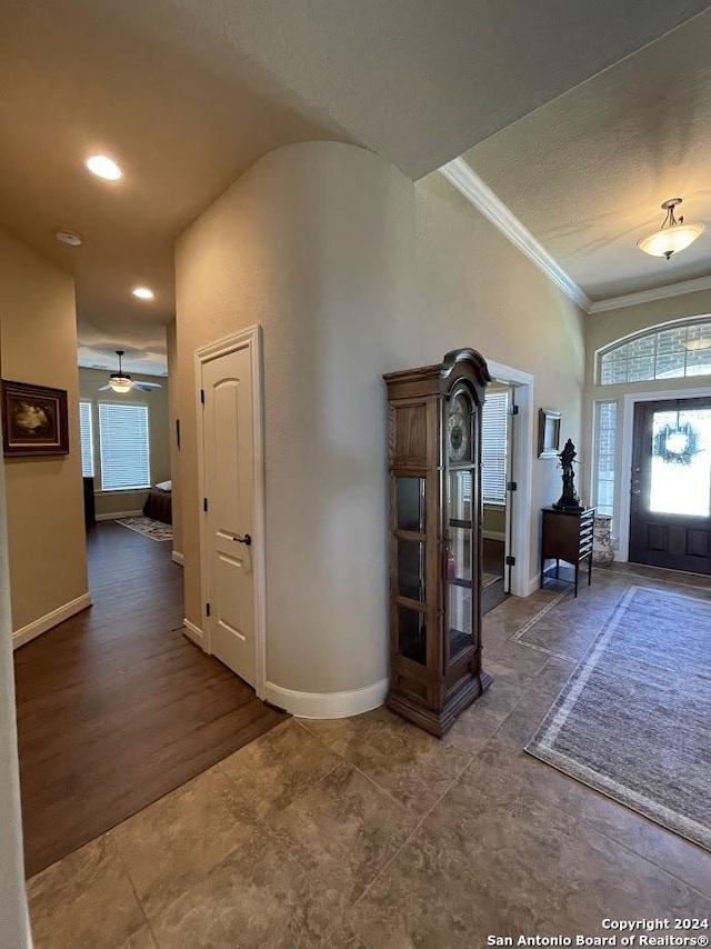 foyer entrance with ornamental molding and baseboards