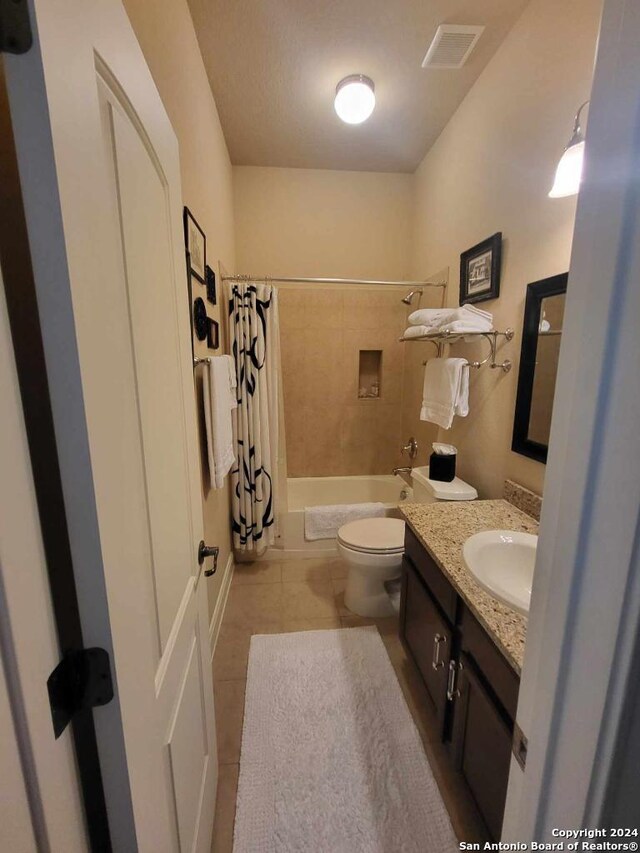 full bath with toilet, shower / tub combo, vanity, visible vents, and tile patterned floors