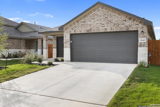 view of front of house featuring a garage, brick siding, concrete driveway, fence, and a front yard