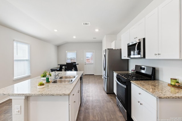 kitchen featuring white cabinets, an island with sink, appliances with stainless steel finishes, wood finished floors, and a sink