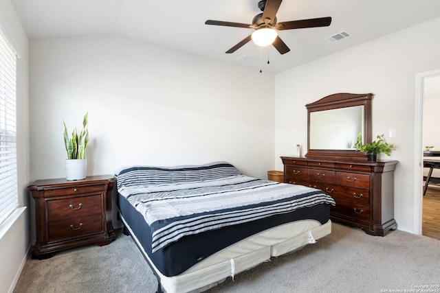 bedroom with lofted ceiling, a ceiling fan, visible vents, and carpet flooring