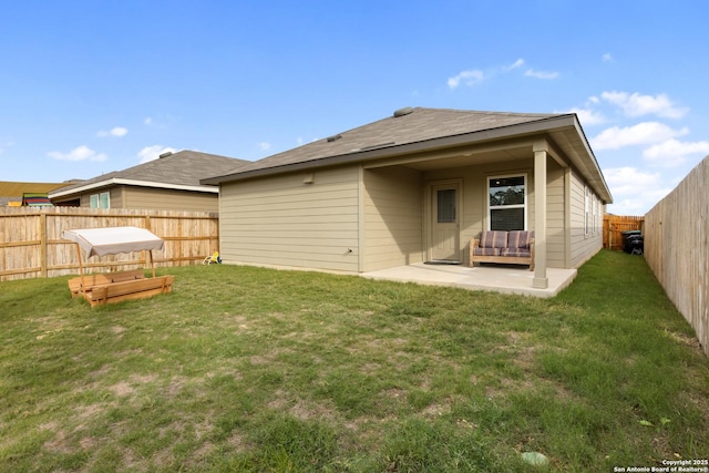 rear view of property featuring a patio area, a fenced backyard, and a lawn