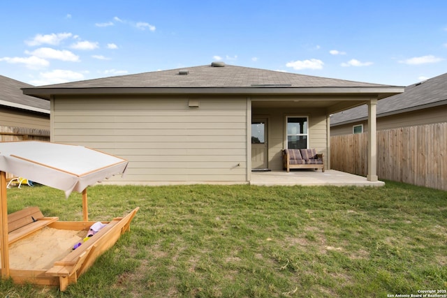 rear view of property with a patio area, fence, and a yard