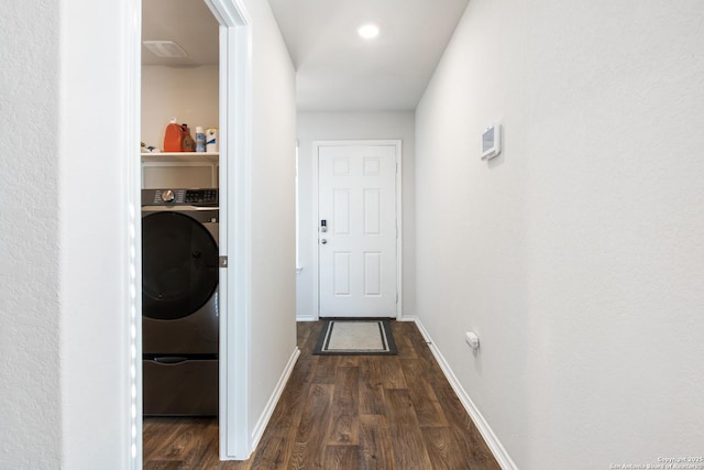 clothes washing area with washer / dryer, baseboards, laundry area, and wood finished floors