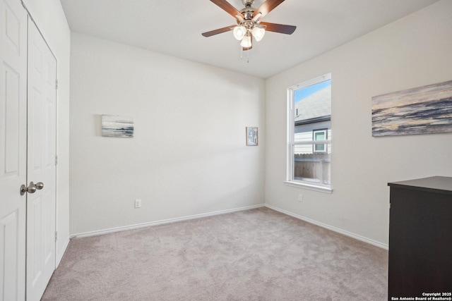 unfurnished bedroom with a ceiling fan, carpet, and baseboards