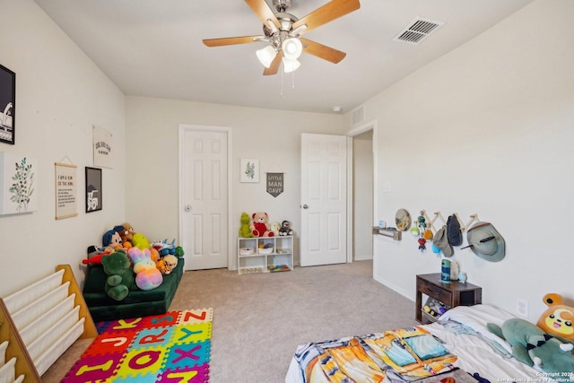 carpeted bedroom featuring a ceiling fan and visible vents