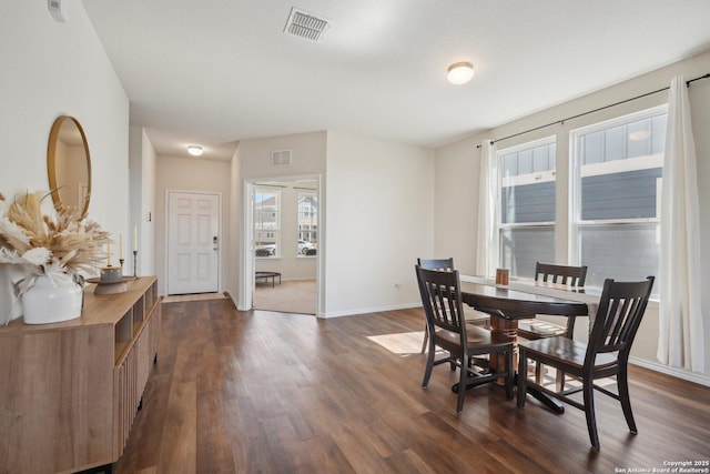 dining room featuring dark wood-style flooring, visible vents, and baseboards