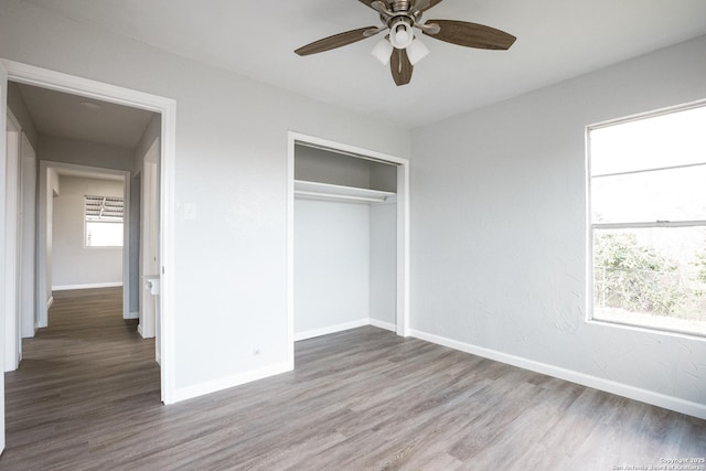 unfurnished bedroom featuring a closet, wood finished floors, and baseboards