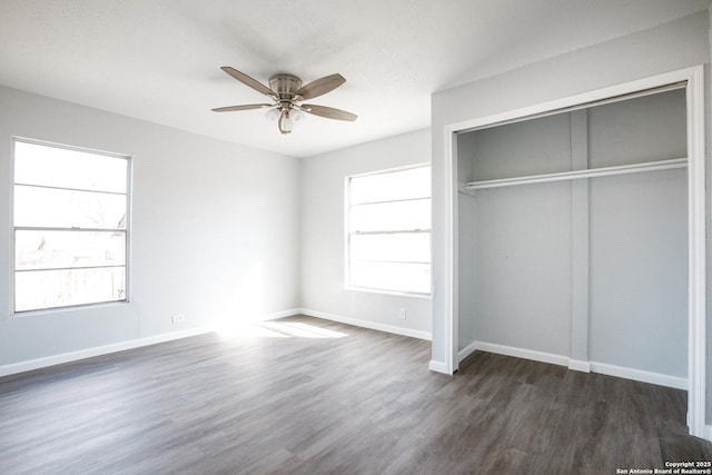 unfurnished bedroom featuring a ceiling fan, a closet, dark wood finished floors, and baseboards