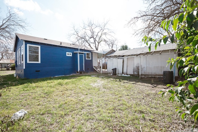 back of property with a yard and crawl space