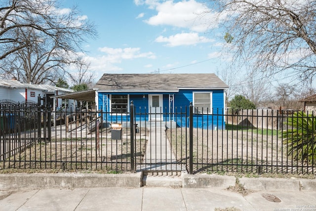 bungalow with a fenced front yard, a gate, and a carport