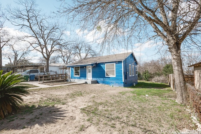 bungalow-style home with a front yard and fence