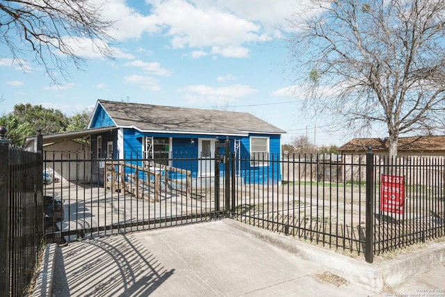 view of front of house featuring a fenced front yard, a gate, and roof with shingles