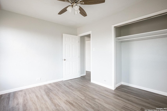 unfurnished bedroom with ceiling fan, a closet, baseboards, and wood finished floors