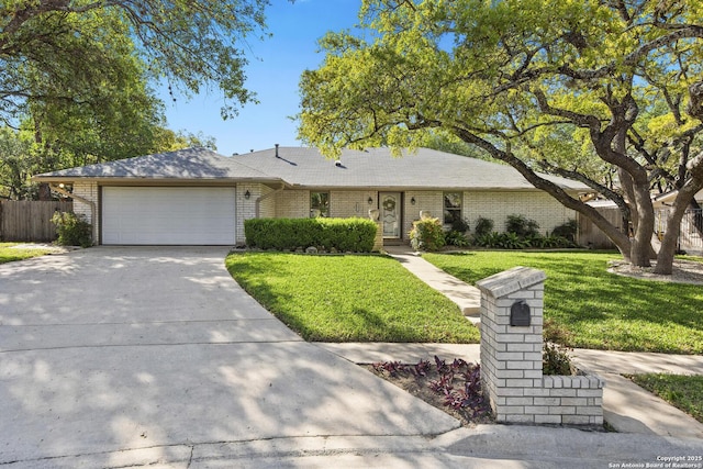 view of front of house with a garage, a front yard, fence, brick siding, and concrete driveway