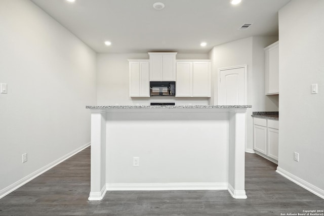 kitchen featuring dark wood-style floors, visible vents, white cabinets, black microwave, and baseboards