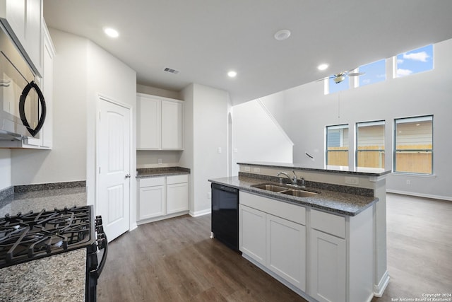 kitchen with visible vents, dark wood-style flooring, black appliances, white cabinetry, and a sink