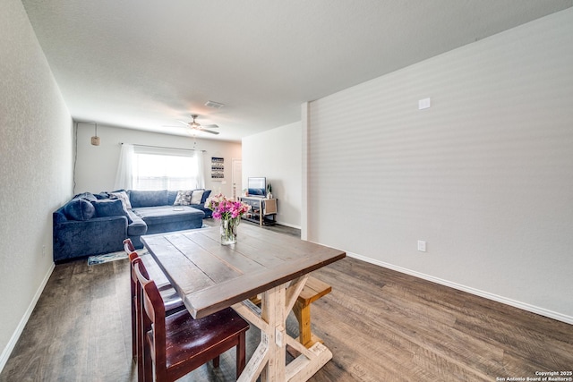 dining room with dark wood-style flooring, visible vents, ceiling fan, and baseboards