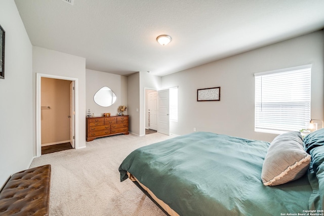 bedroom featuring light carpet and baseboards