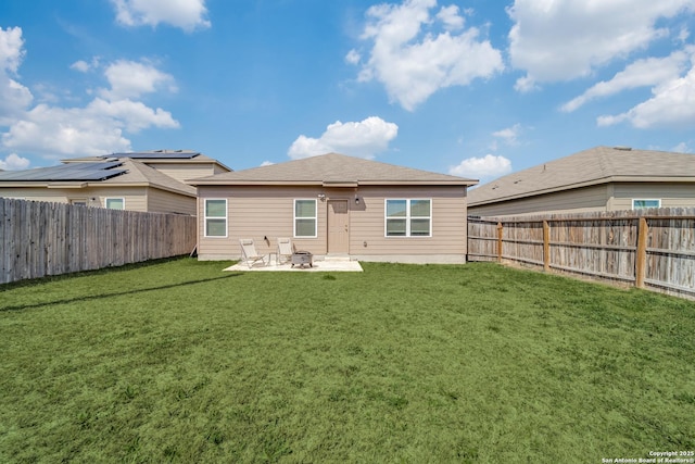 back of house featuring a lawn, a patio area, and a fenced backyard