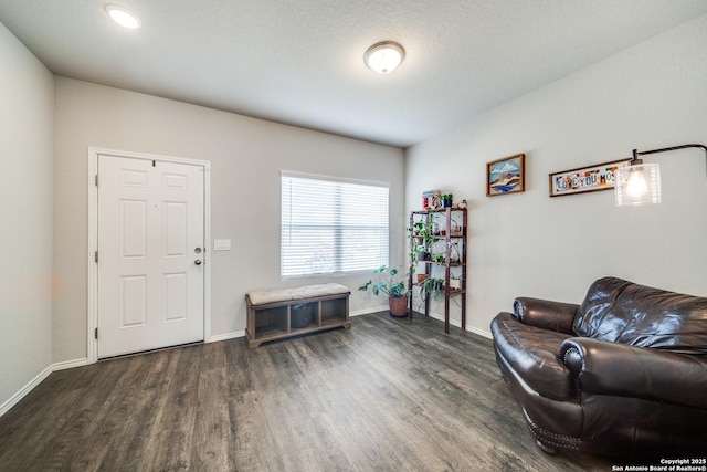 living area with baseboards and wood finished floors