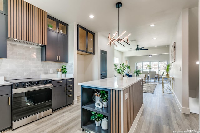 kitchen with light wood finished floors, light countertops, electric range, and decorative backsplash