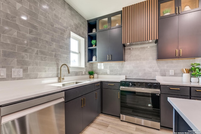 kitchen with a sink, light countertops, stainless steel dishwasher, backsplash, and electric range oven