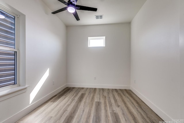 spare room featuring ceiling fan, wood finished floors, visible vents, and baseboards