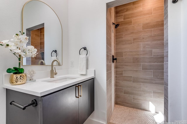 bathroom featuring a tile shower and vanity