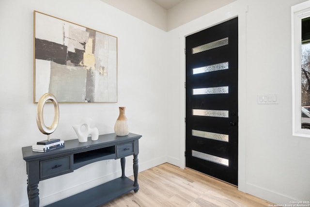 foyer featuring light wood-style flooring and baseboards