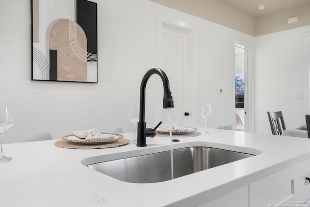 interior details with white cabinets and a sink