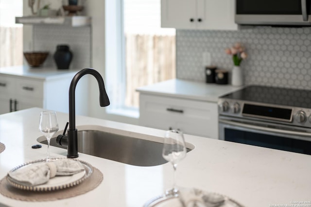 kitchen featuring plenty of natural light, appliances with stainless steel finishes, decorative backsplash, and light countertops