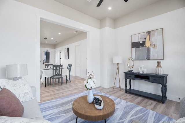 living room featuring a ceiling fan, recessed lighting, baseboards, and wood finished floors