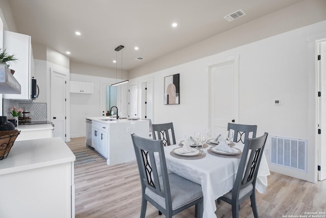 dining space with baseboards, light wood finished floors, visible vents, and recessed lighting