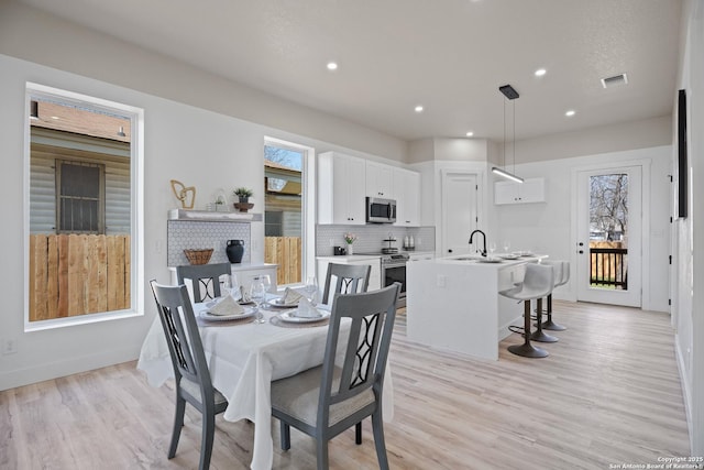 dining space with light wood-style floors, baseboards, visible vents, and recessed lighting