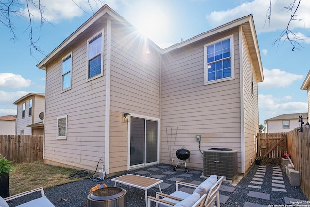 rear view of property with a patio, a fenced backyard, and cooling unit