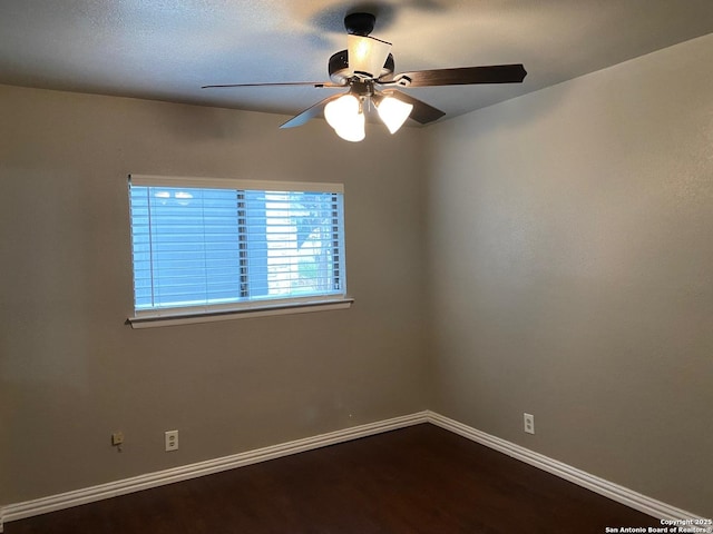 unfurnished room featuring dark wood-style floors, baseboards, and a ceiling fan