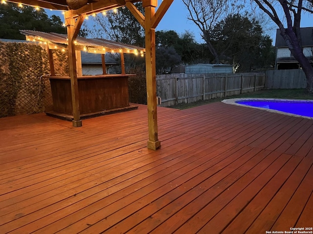 deck featuring a fenced in pool, a fenced backyard, and a jacuzzi