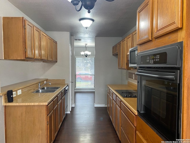 kitchen with visible vents, dark wood finished floors, light countertops, black appliances, and a sink